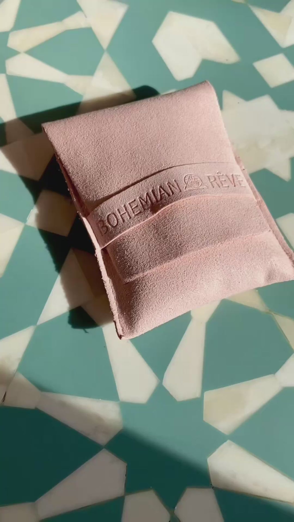 Bohemian Rêves perfume discovery set travel sprays featuring Desert Fleur, Lagoon and Canggu sliding from vegan suede pouch.